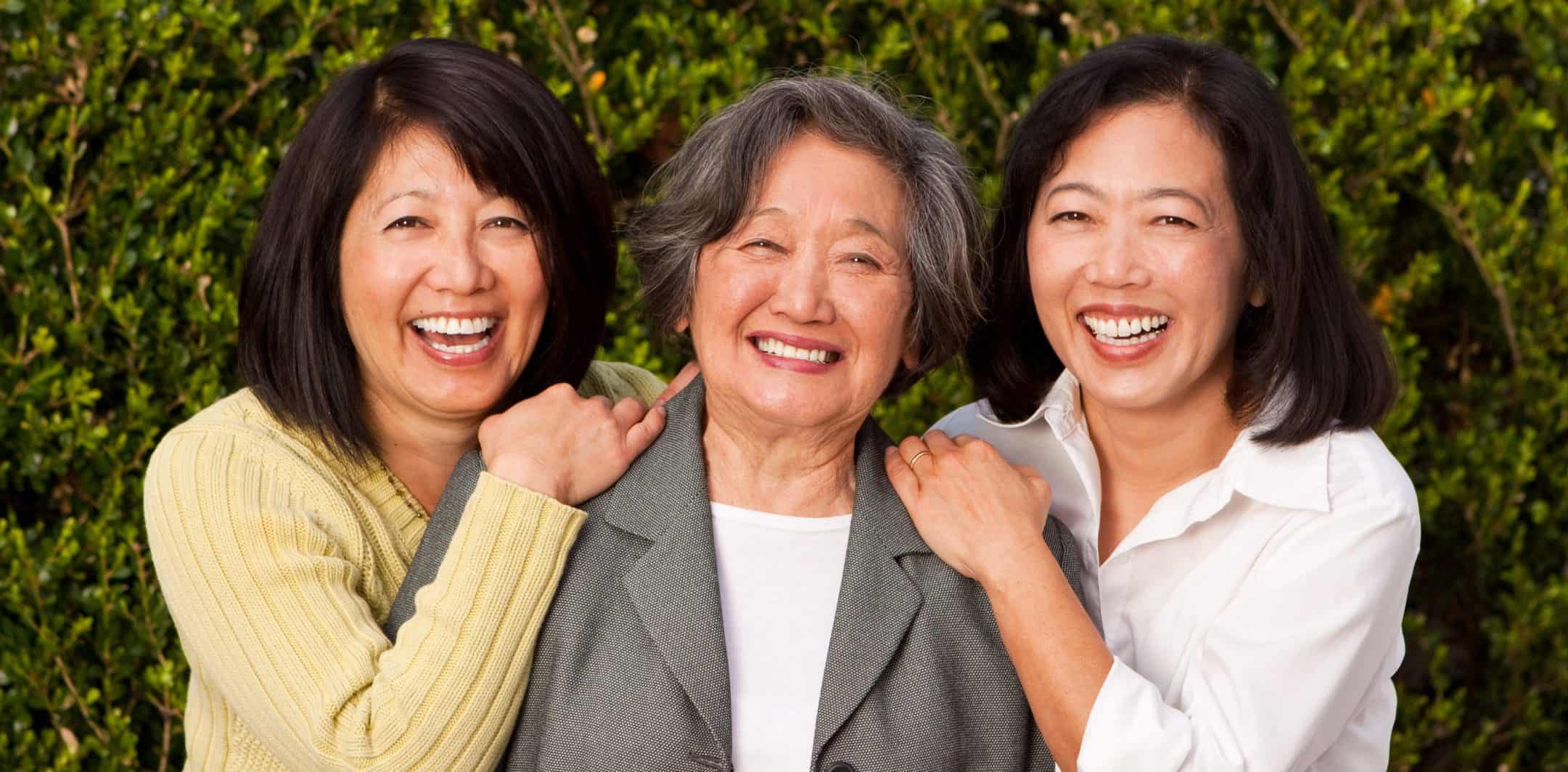 Happy mature Asian mother and her adult daughters.