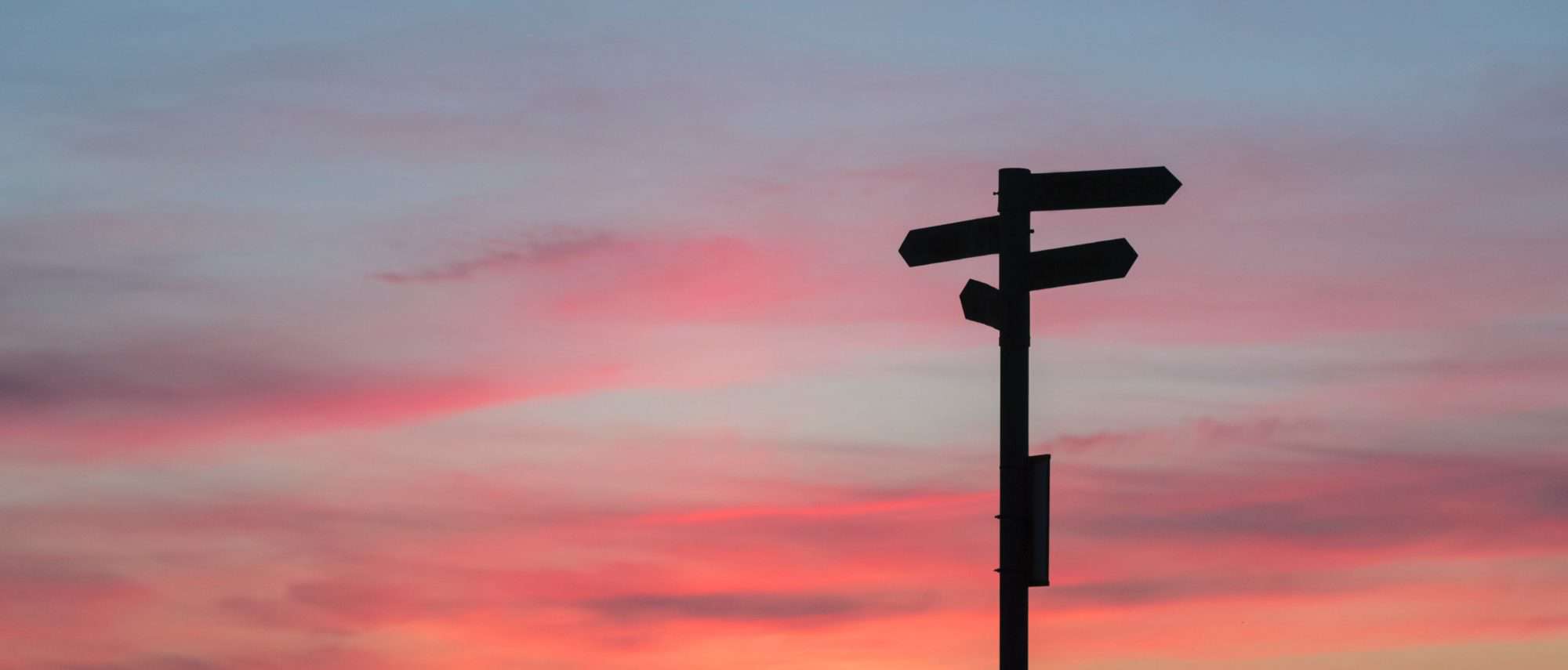 Silhouette of a sign post at sunset