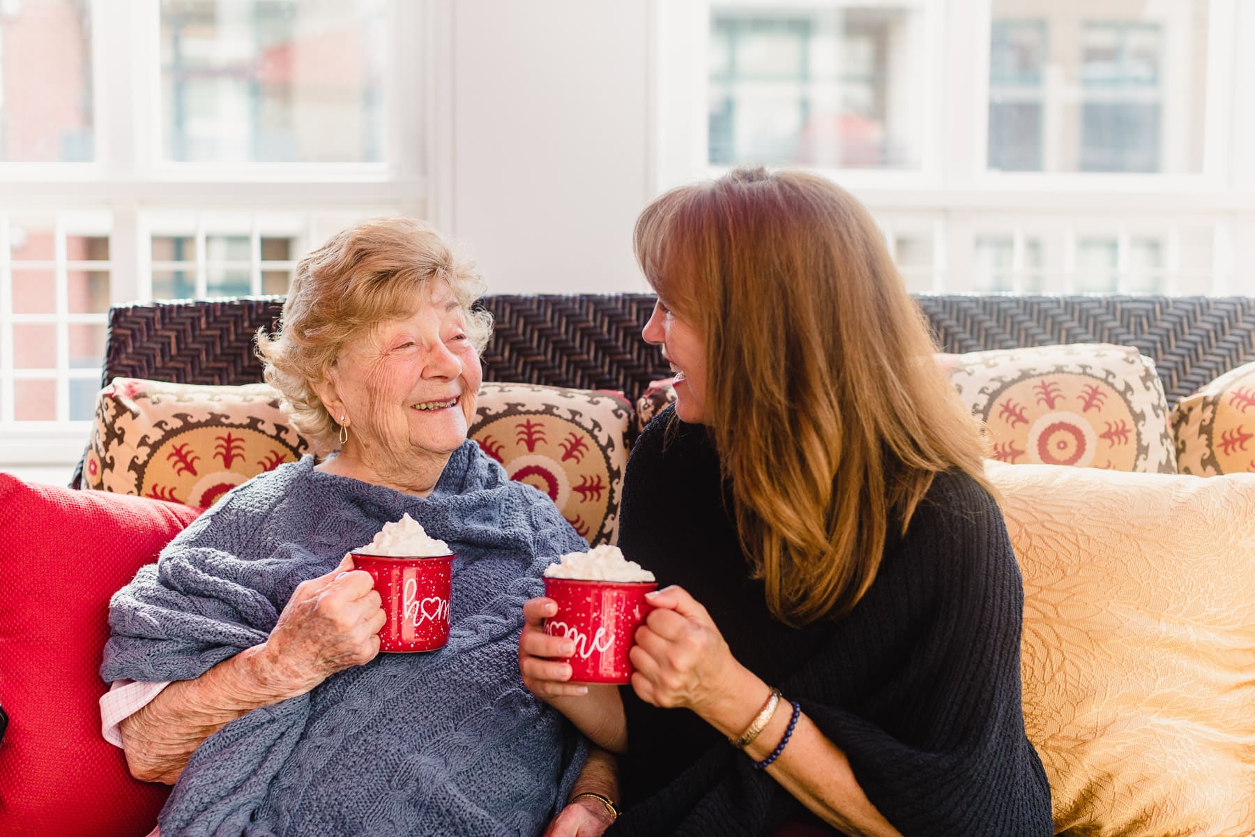elderly woman with caregiver holding coffee