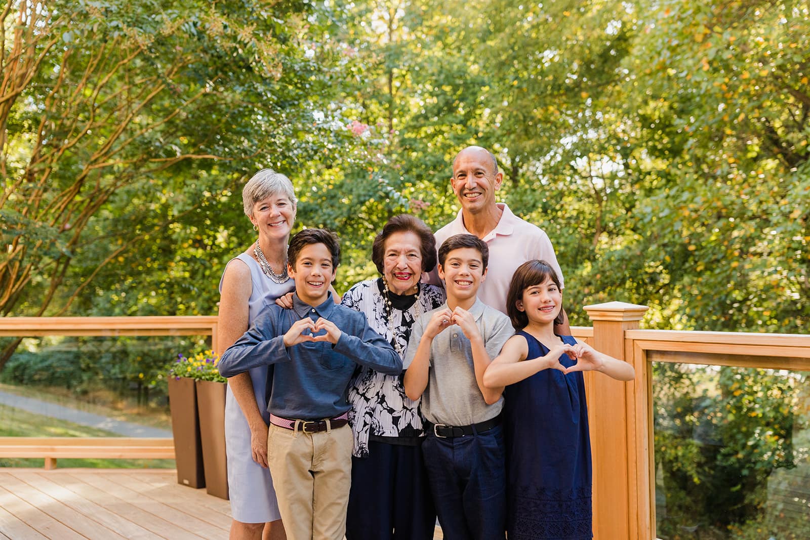 family making hearts with their hands outside