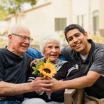 senior husband and wife with son and sunflower