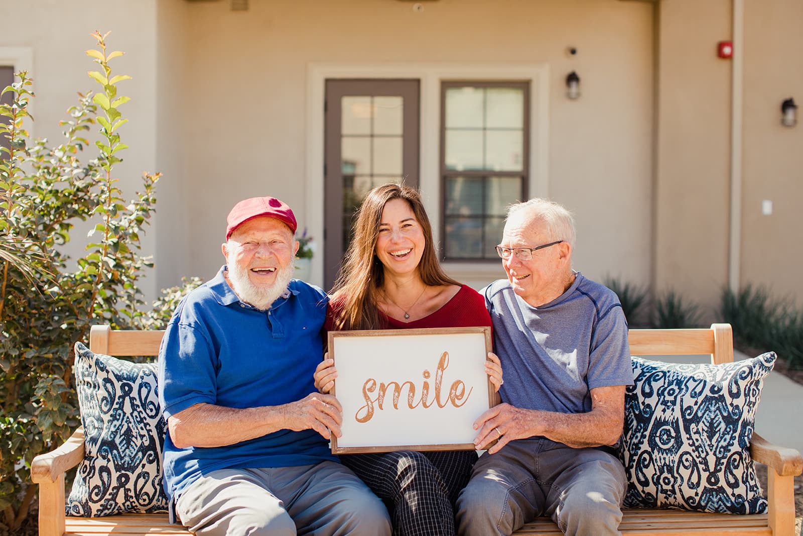 seniors and woman holding a sign that says smile