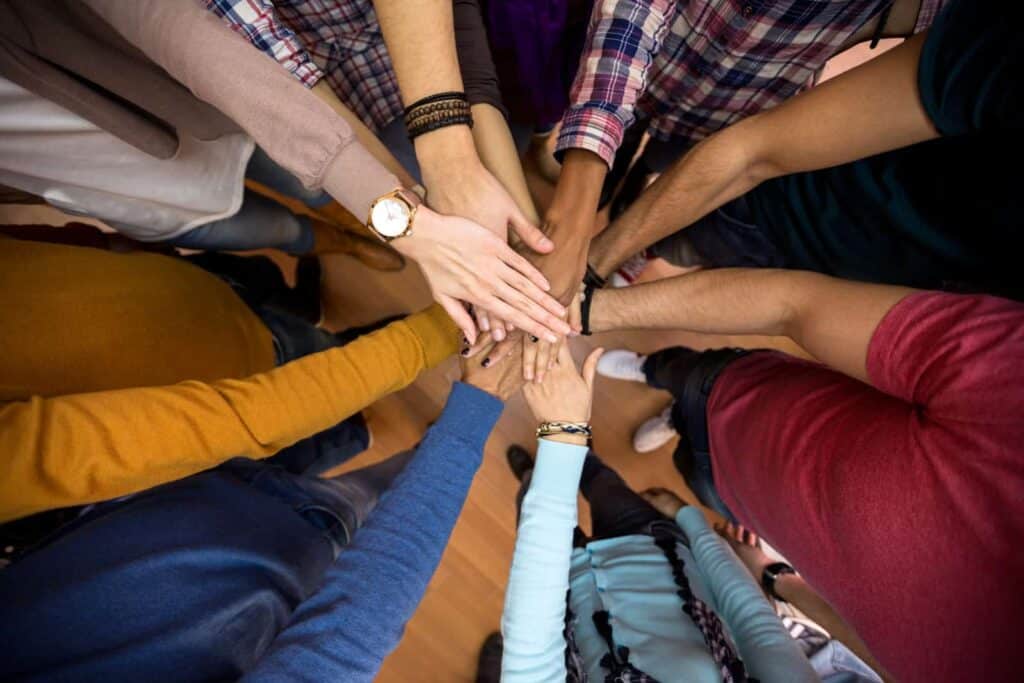 team members with hands in huddle