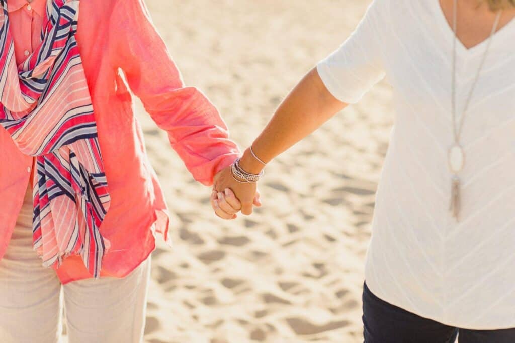 adult woman and elderly woman holding hands