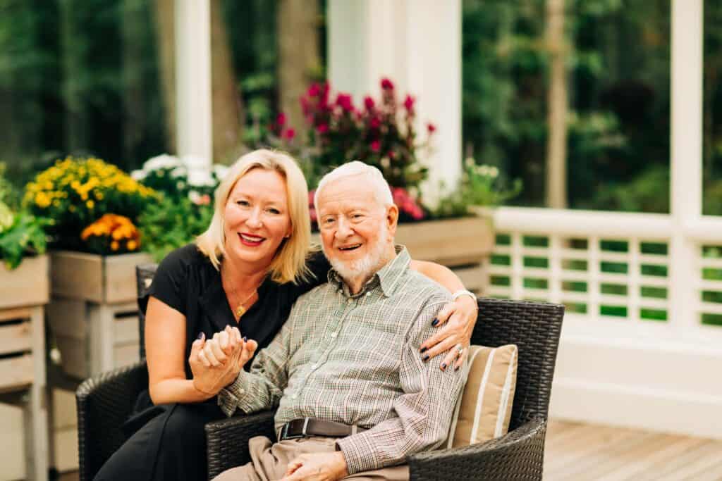 senior citizen and adult woman sitting in patio