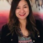 A woman wearing sunglasses and a black jacket.