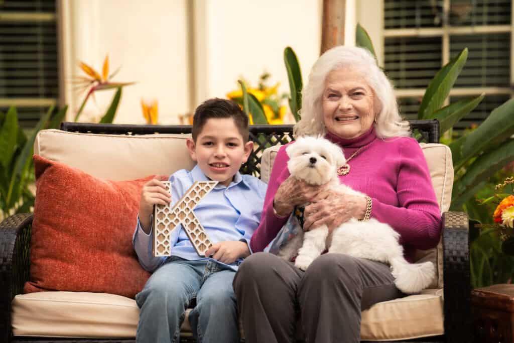 old woman sitting with young boy and little dog
