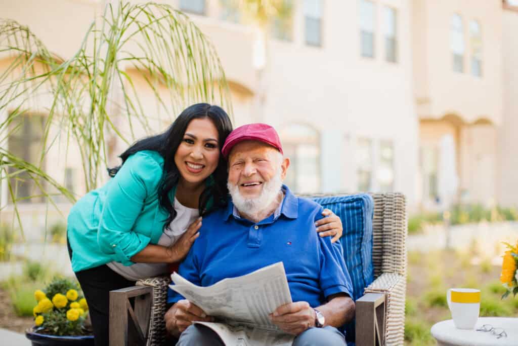 woman hugging old man holding newspaper