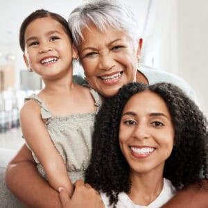Family, generations and hug with love in portrait and care at home, mother and grandmother with child together and smile. Happiness, relationship and wellness, women and girl quality time together